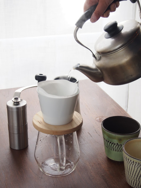 コーヒーを淹れるためにやかんから注ぐお湯