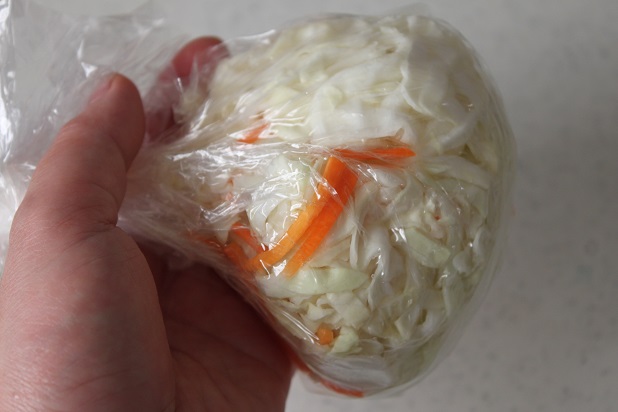 キャベツとにんじんをビニール袋にいれてなじませる
