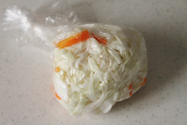 キャベツとにんじんをビニール袋にいれてなじませる