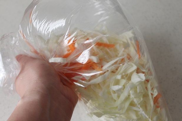 キャベツとにんじんをビニール袋にいれてふる