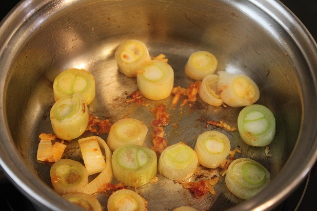 小鍋に豆板醤としょうが、5mm幅に切った長ねぎ、ごま油を入れて中火で炒める。