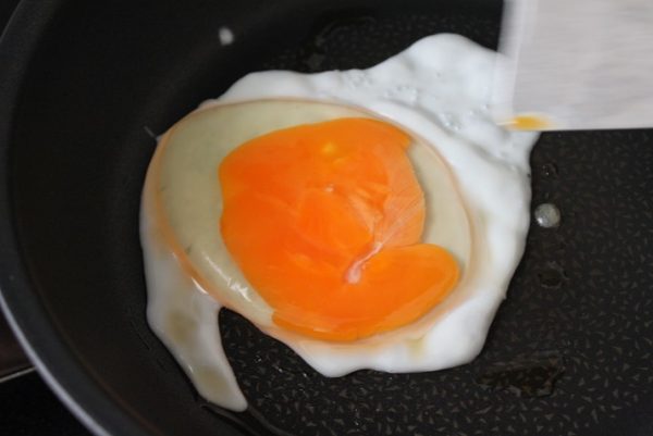 フライパンにごま油を入れてツナ缶の油を入れて中火で熱し、卵を割り入れて、ヘラ等で黄身をつぶす