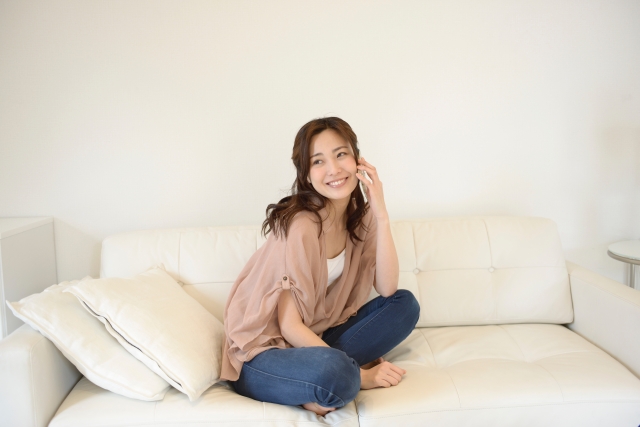 あぐらをかいて電話する女性