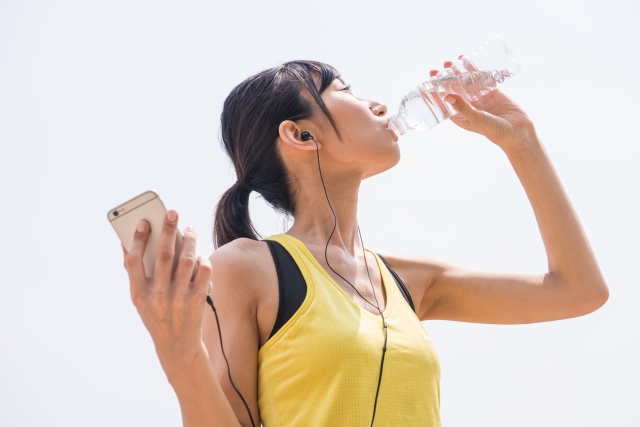 ペットボトルのお水を飲む女性