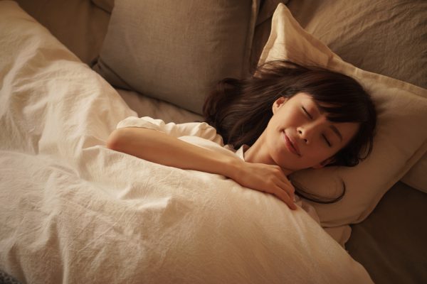 夜ベッドで睡眠中の女性