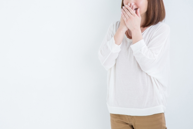 口を抑える女性