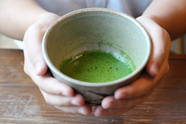 両手で抹茶を持つ