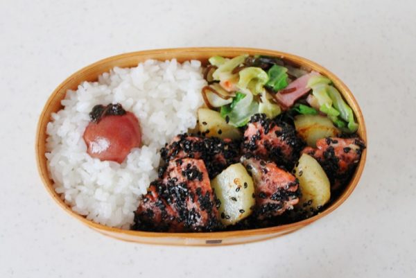 隙間に、塩昆布炒めを追加する。ごはんを少しくぼませて梅干しを詰める。