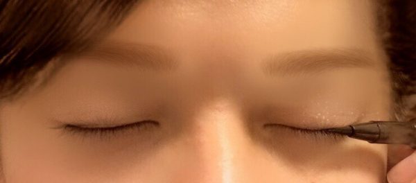 アイラインをひく女性