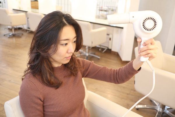 ドライヤーをかける女性