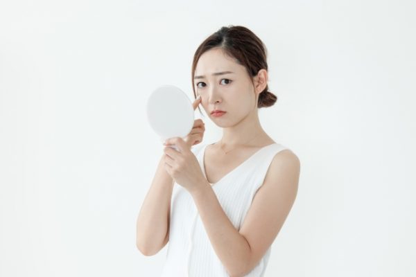 肌荒れ、シワをチェックする女性