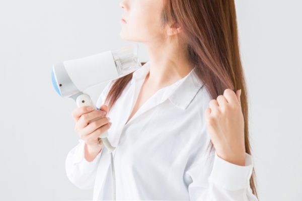 ドライヤーをかける女性