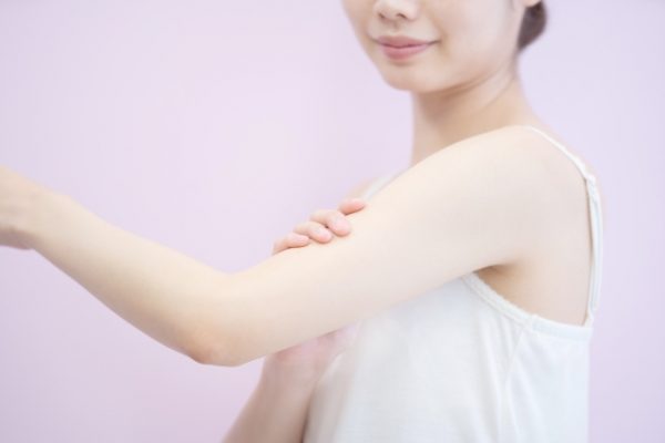 二の腕をマッサージする女性