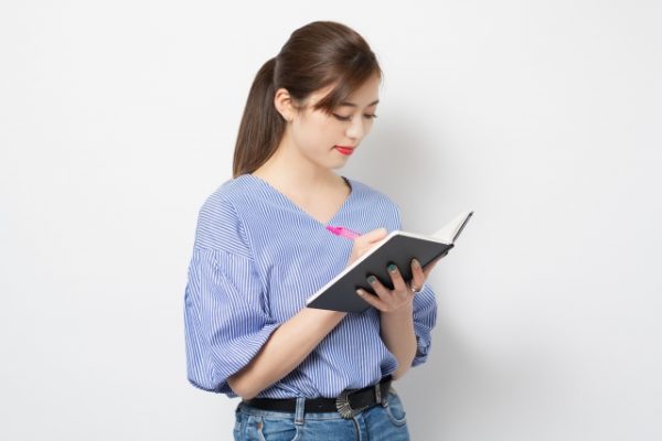 ノートを書く女性