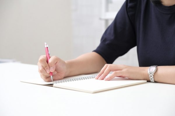 ノートを書く女性