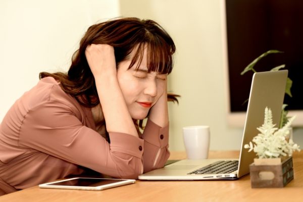 仕事中に頭を抱える女性