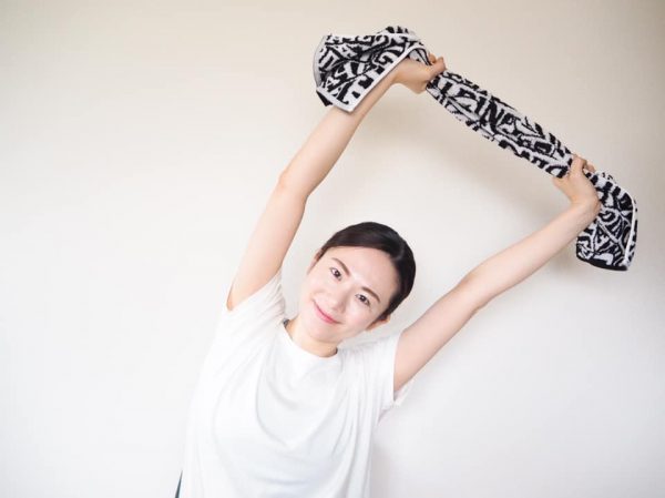 タオルでストレッチをする女性