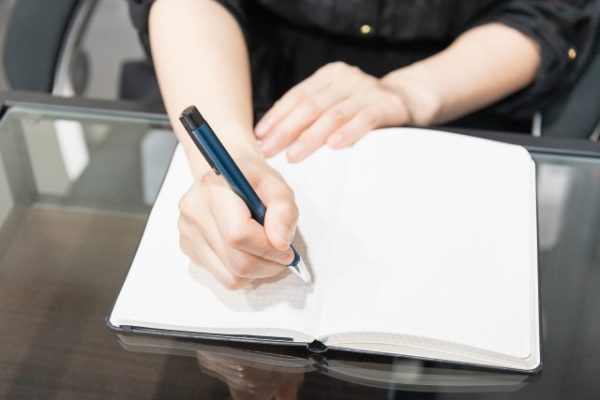 ノートを書く女性