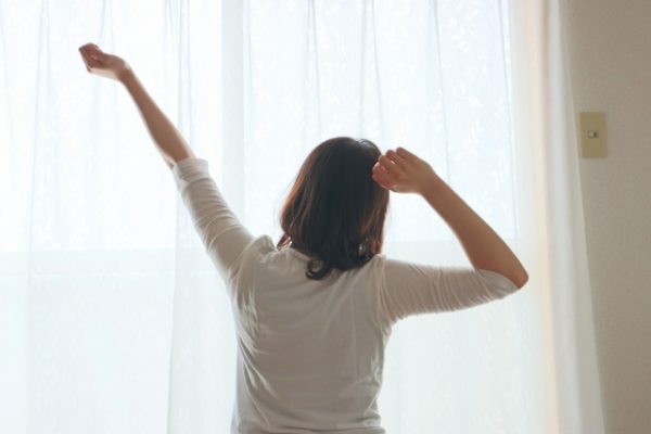 朝起きて伸びをする女性