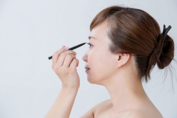 アイラインを引く女性
