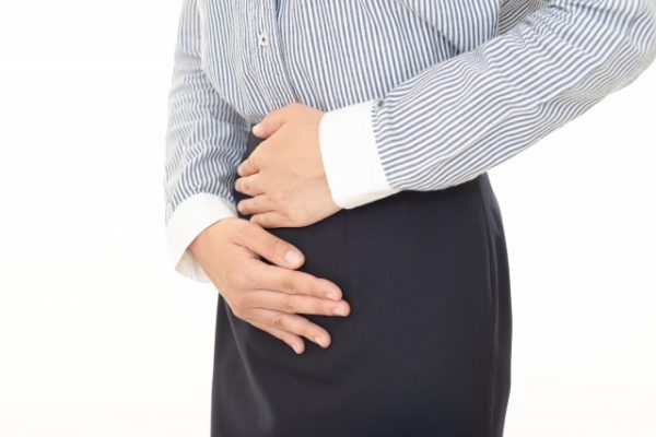 お腹を抑える女性