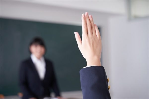 教室で手を挙げる生徒