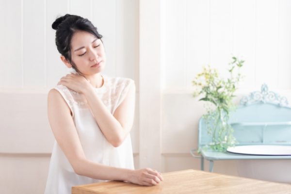 肩を抑える女性