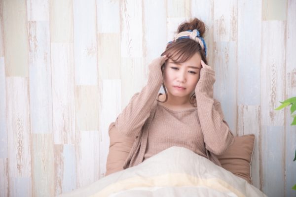 頭を抑える女性