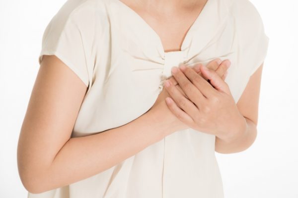 胸元をおさえる女性のイメージ