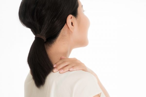 肩をおさえる女性