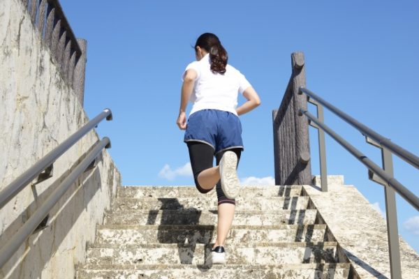 足を上げて歩く女性