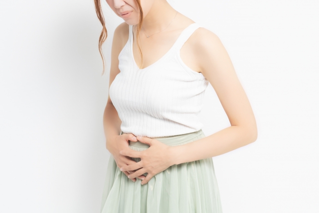 お腹をおさえる女性