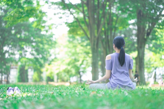 朝に公園で瞑想する女性