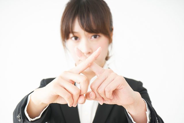 NGジェスチャーをする女性