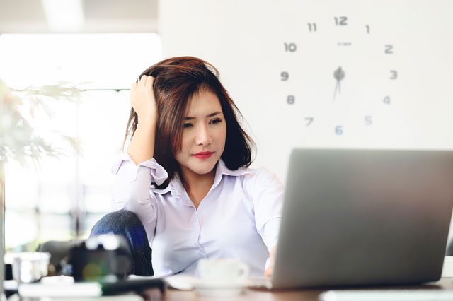 忙しくて頭を抱える女性