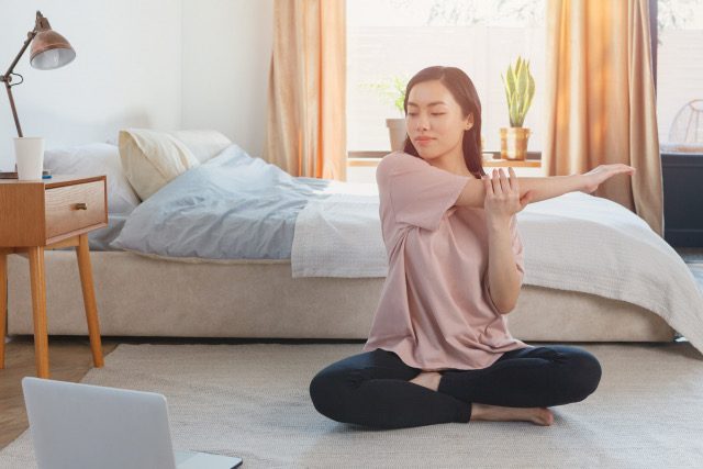 部屋でストレッチをする女性