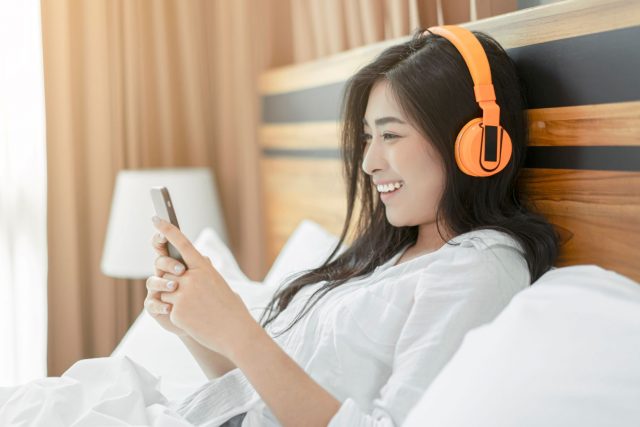 ベッドで音楽を聴く女性