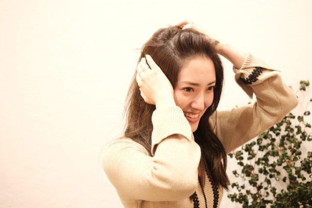 ヘアオイルをつける女性