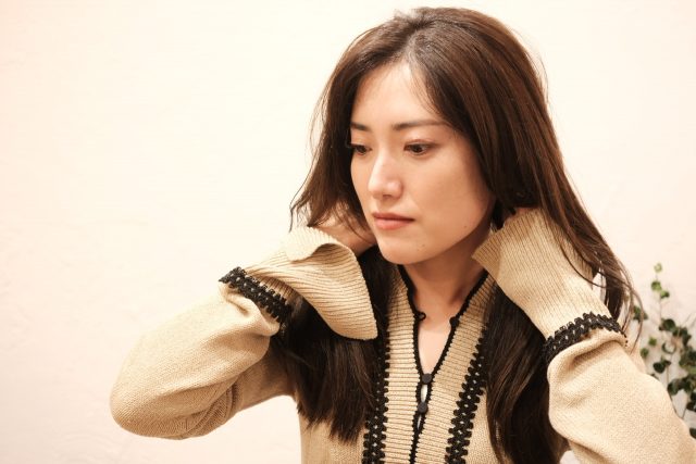 ヘアオイルをつける女性