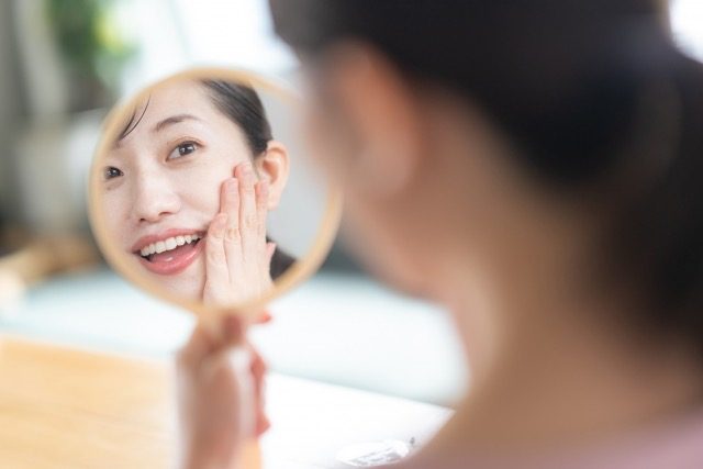 顔を鏡で見る女性