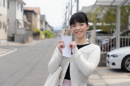 お金をもって笑顔の女性