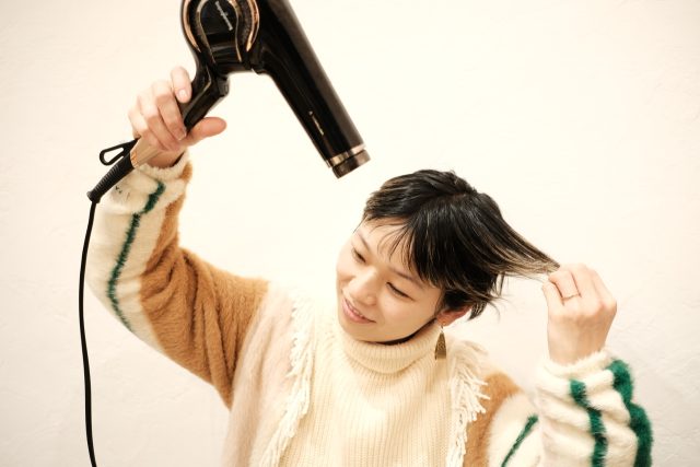 ドライヤーを当てる女性