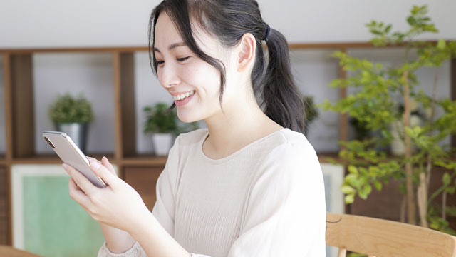 笑顔でスマホを操作する女性