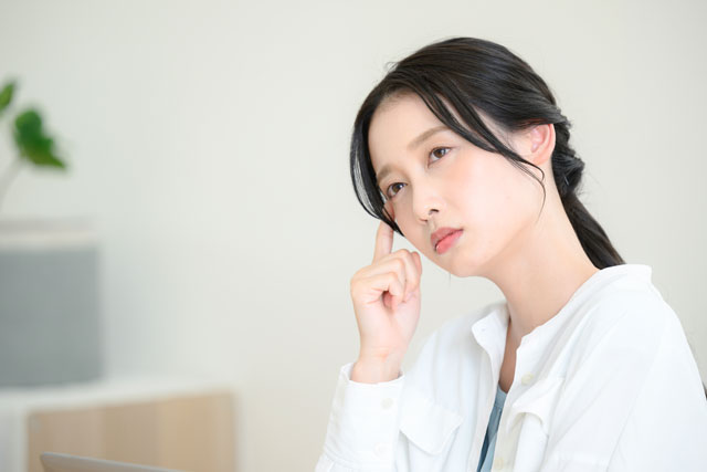 首を傾げる女性