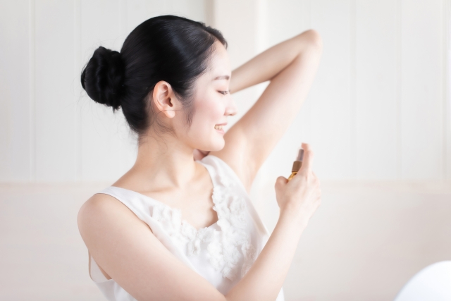 デオドラントスプレーを使う女性