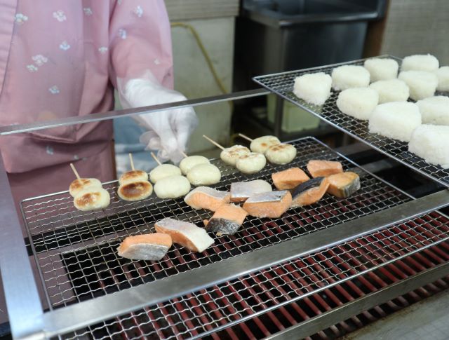 網の上で焼かれる鮭や饅頭