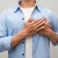 胸に手を当てる男性