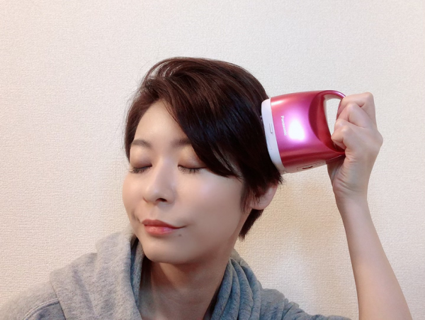 美容家電でヘッドマッサージをする女性
