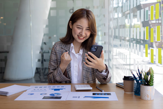 株価をスマホでチェックする女性