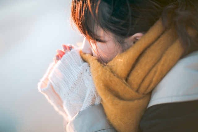 手を温める女性